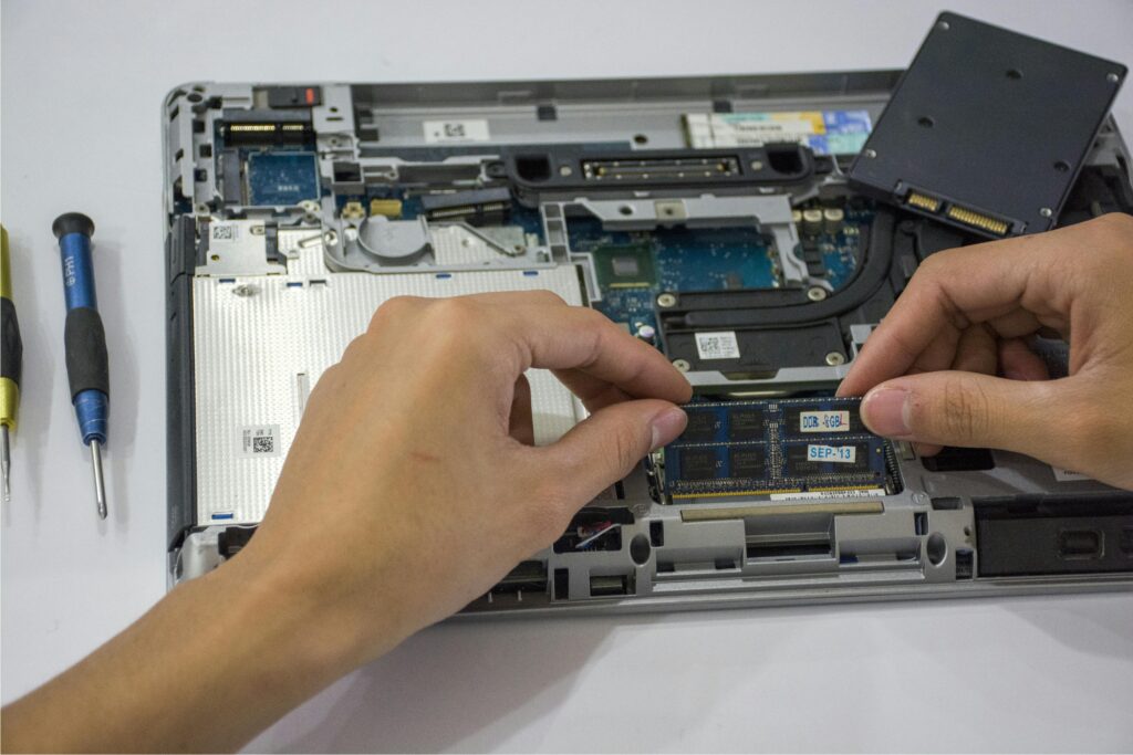 A Hand Fixing the Internal Parts of a Laptop